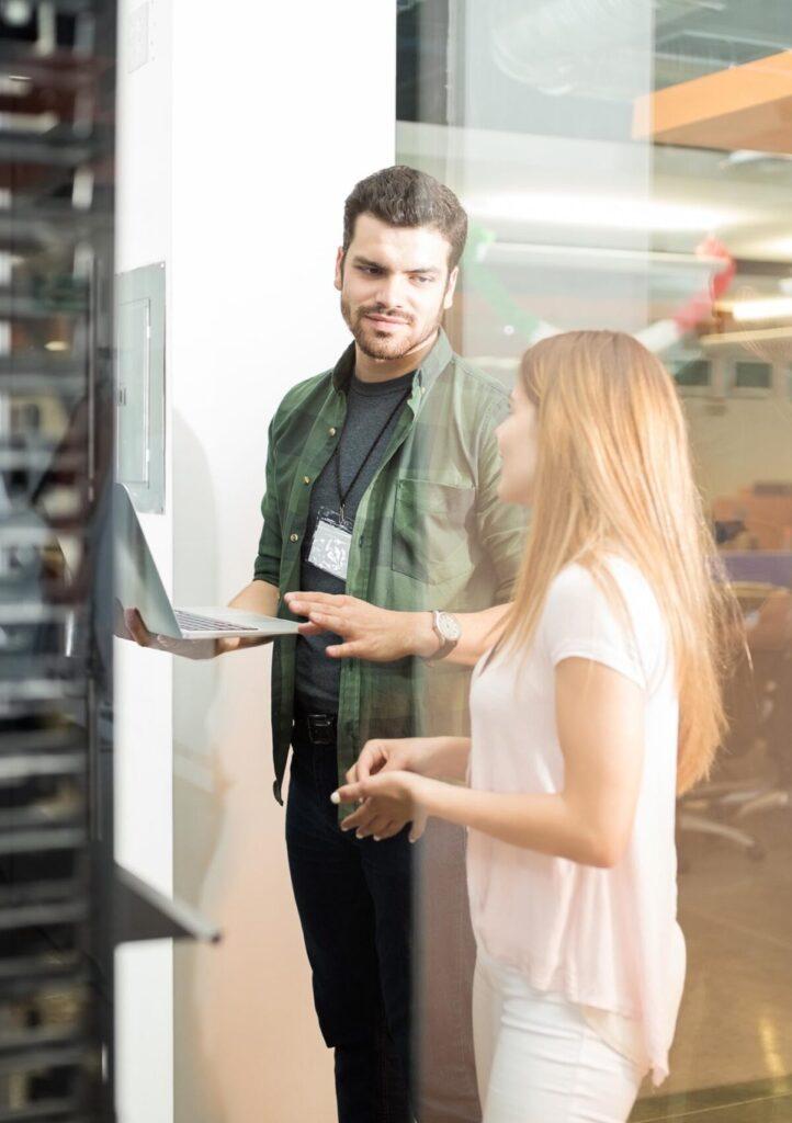 IT worker and client standing in server room